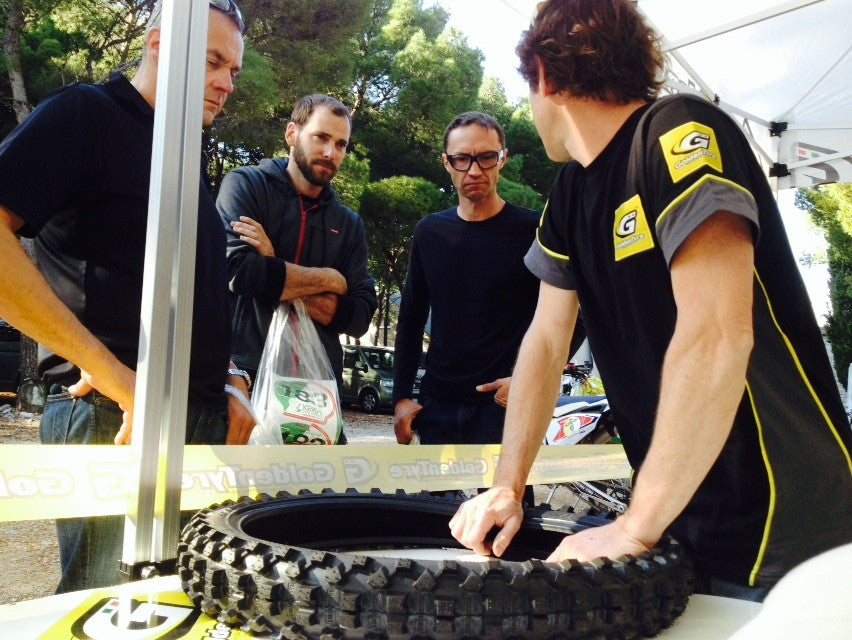 Goldentyre tent — staff explaining knobby tyre on the table